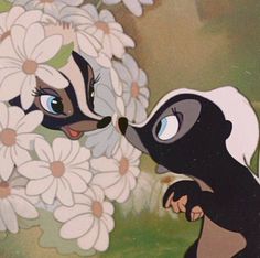 the skunks are kissing each other in front of flowers