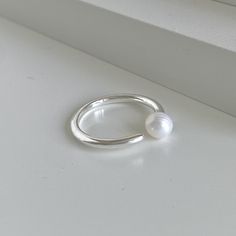 "Dive into elegance with the Dainty Adjustable Sterling Silver Pearl Ring. Expertly crafted from high-quality 925 Sterling Silver, this unique ring encapsulates the radiant beauty of nature with its nearly round, natural freshwater pearl delicately embraced on one side. Designed as a waterproof ring, it perfectly marries functionality with beauty, allowing you to wear it come rain or shine. The dainty pearl ring's open face design not only creates a modern, minimalist ring aesthetic but also ens Silver Pearl Ring, Freshwater Pearl Ring, Open Ring, Minimalist Rings, Silver Pearls, Pearl Ring, Unique Rings, Ring Designs, Freshwater Pearls