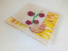 a glass plate with flowers on it sitting on a white counter top next to a pair of scissors