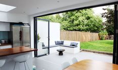 an open kitchen and living room area with sliding glass doors to the back yard outside