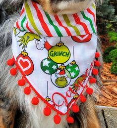 a small dog wearing a bib with the word grin on it's chest