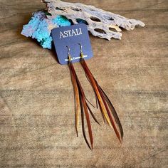 -These delicate earrings are incredibly soft to the touch.  Gold-color chains peak out between the feathers to add texture.-Coque feathers are from unique roosters that grow these exceptionally long feathers and shed them once a year.  These birds have been bred for over 100 years by fly fishermen, who use the feathers as fishing lures.  Sustainably sourced in the USA.  -Perfect to pair with your favorite sundress or swimwear.  Feathers can get wet and will be just fine.  -Adds a feminine touch Elegant Brown Feather Earrings, Brown Feather Dangle Earrings, Black Statement Earrings, Feather Fringe, Earrings Feather, Bridal Party Attire, Dream Catcher Earrings, Boho Hippie Chic, Party Kleidung