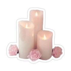 three white candles with pink roses on them