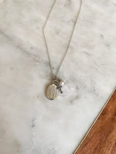 This beautiful Sterling Silver First Communion Gift with "Miraculous Medal" necklace is accented with a dainty cross charm and pearl charm. It floats on a 14" sterling silver Italian chain. It is a perfect Baptism, First Communion or Confirmation gift for girls. The necklace comes in a beautiful black and pink gift box. A keepsake she will treasure forever! This comes packaged on a special first communion card making it an extra special keepsake for her special day. Sterling Silver Charm Necklace With Cross Pendant, Silver Cross Necklace With Pearl Charm, Sterling Silver White Gold Necklace For First Communion, Sterling Silver Necklace For First Communion, Silver Cross Pendant Charm Necklace, Dainty Silver Necklace With Miraculous Medal, Silver Crucifix Necklace With Charms, Personalized Sterling Silver Necklace For Baptism, Silver Dainty Jewelry For Baptism