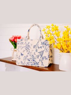 Carry your summer essentials in style in this Blue and White Bird and Floral Tote. This soft but structured canvas bag features an elegant and feminine bird and floral design in a classic blue and white color scheme. With its classic colors and durable body, this will be your favorite summer tote for years to come. Cotton, double handles, magnetic snap closure, 1 inner zip pocket, 1 inner slip pocket. Chic Blue Cotton Bag, Spring Vacation Canvas Bag, Blue Floral Print Shoulder Bag For Spring, Spring Travel Canvas Bag, Blue Canvas Bag For Everyday Use In Spring, Spring Cotton Shoulder Bag With Double Handle, Spring Cotton Double Handle Shoulder Bag, Spring Double Handle Cotton Shoulder Bag, Summer Blue Canvas Bag