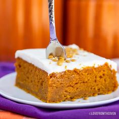 a piece of cake on a white plate with a fork stuck in it and topped with frosting