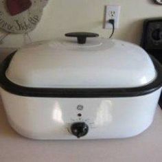 a white crock pot sitting on top of a counter next to a microwave oven