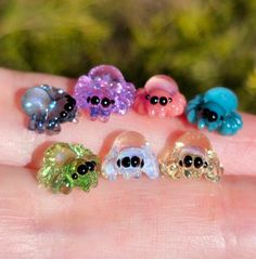 five little skulls are sitting on the palm of someone's hand, all in different colors