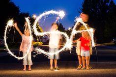 three children holding sparklers in the shape of numbers