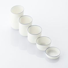 five white cups lined up in a row