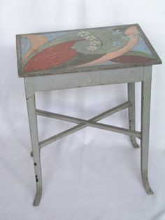 an old table with a painted design on the top and bottom, sitting against a white background