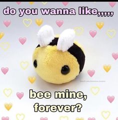 a yellow stuffed animal with black and white ears on it's head, sitting in front of hearts