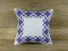 a blue and white pillow sitting on top of a wooden floor