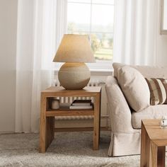 a living room scene with focus on the couch and coffee table in front of the window