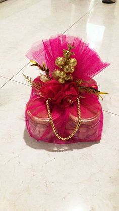 a pink purse with gold decorations on it sitting on top of a white tile floor