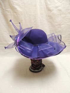 Vintage Purple Red Hat Society in Wool and Tulle with Sequins. This is a vintage Red wool hat society hat and is one size fits all. A beautiful purple floppy hat with brim turned up in the front, decorated with purple tulle, a purple sequined applique and tiny sequined at the end of each bough of tulle. The Red Hat Society is an international social organization that was founded in 1998 in the United States for women age 50 and beyond, but now open to women of all ages. Its main purpose is to pr Fitted Purple Hat With Short Brim, Vintage Purple Hat With Short Brim, Vintage Short Brim Purple Hat, Adjustable Purple Top Hat With Curved Brim, Adjustable Purple Felt Hat With Short Brim, Purple Hat With Short Brim For Royal Ascot, Purple Top Hat For Royal Ascot, Purple Mini Hat With Curved Brim For Kentucky Derby, Purple Curved Brim Mini Hat For Kentucky Derby