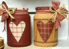 two jars with hearts painted on them sitting next to each other in front of a shelf