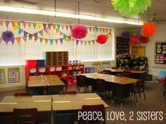 a classroom filled with desks and chairs covered in paper lanterns hanging from the ceiling