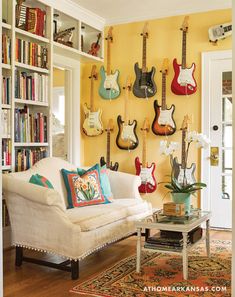 a living room with guitars on the wall