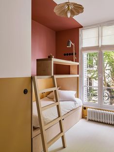 a bunk bed sitting next to a window with a ladder on it's side