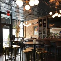 an empty bar with lots of stools and tables