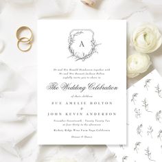 the wedding stationery is laid out on top of white paper with flowers and rings