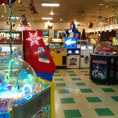 the inside of a store with arcade machines and snow globes on the ceiling,