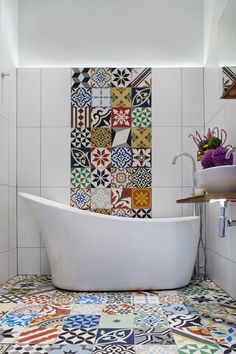 a bath tub sitting next to a white sink in a bathroom under a faucet