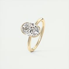 a yellow gold ring with an oval cut diamond in the center, on a white background