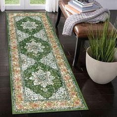 a large green rug in the middle of a room with a chair and potted plant