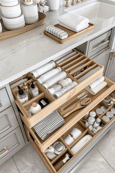 an open drawer in a kitchen filled with dishes and utensils