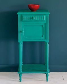 a green cabinet with a red bowl on top