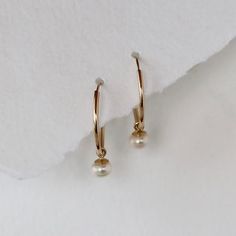 Endless hoops in solid 14k yellow gold are accented with white cultured pearl dangles. The hoops are 15mm in diameter and the cultured pearls are 4mm each. This is not gold filled metal, this is solid 14k gold. A cultured pearl is a genuine pearl, produced by an oyster or mollusk with human assistance. Endless hoops open with a little tension, and you slip the post through your ear and use a little tension to put the post back into the hoop. The pearl dangle can be slipped on and off, creating t White Teardrop 14k Gold Hoop Earrings, Classic Dangle Hoop Earrings With Pearl Charm, Dainty 14k Gold Hoop Earrings With Pearl Drop, Classic White 14k Gold Filled Hoop Earrings, Classic 14k Gold Hoop Earrings With Pearl Drop, 14k Gold Huggie Hoop Earrings With Pearl Drop, Yellow Gold Hoop Earrings With Pearl Charm For Anniversary, Classic Yellow Gold Huggie Earrings With Pearl Charm, Anniversary Yellow Gold Hoop Earrings With Pearl Charm