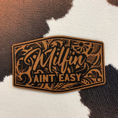 a brown and white cow print with the words milfin easy on it