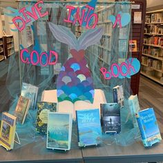 there is a display in the library with books and signs on it that say, dive into a good book