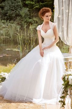 a woman in a white wedding dress sitting on a bench