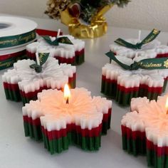 small candles with red, white and green designs on them are sitting on a table