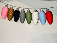 there are five different colored ornaments hanging from the line