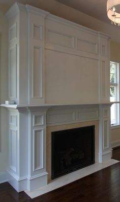 an empty living room with a fireplace and white mantles on either side of the fire place