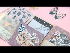 several different types of cards on a pink surface with gold scissors and paper flowers in the middle