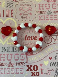 a red and white bracelet with two hearts on it