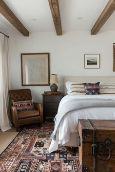 a bedroom with a bed, chair and rug