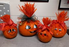 three orange pumpkins with faces painted on them