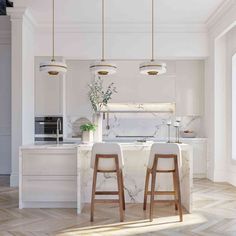 two wooden stools sit in front of an island with marble countertops and white cabinets