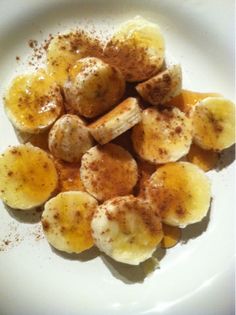 a white plate topped with sliced bananas and cinnamon