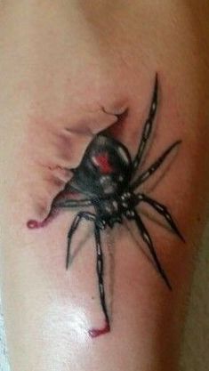 a black and red spider tattoo on the leg