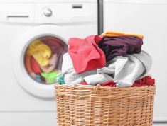 a laundry basket filled with clothes next to a dryer