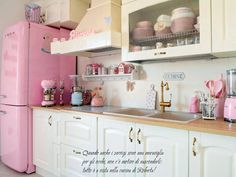 a pink refrigerator freezer sitting inside of a kitchen