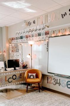 a room with a desk, chair and large white board in the middle of it