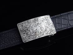 One of our most popular buckles, this understated piece by Comstock Heritage is perfect for those just starting their buckle collections, or for more formal occasions. It’s made from heavy-gauge, hand-engraved Sterling silver, and its rectangular face is adorned with beautiful, delicate scrollwork. This buckle can be paired easily blue jeans or be worn with dressier slacks. Smaller size measures 1 ⅝” x 2 ⅝” and fits all 1 ¼" belt traps Larger version measures 1 ⅞” x 2 ¾" and fits all 1 ½" belt s Luxury Formal Belts With Silver Buckle, Luxury Formal Belt With Silver Buckle, Designer Formal Belt Buckle Rectangular, Luxury Formal Jewelry With Silver Buckle, Classic Silver Belt With Palladium Hardware, Luxury Silver Belt Buckles For Business, Classic Formal Belt With Silver Buckle, Elegant Formal Belt With Rectangular Buckle, Vintage Engraved Belt Buckles For Formal Wear